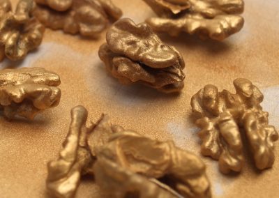 Der goldene Überzug – eine eigens für den Verzehr und für die Veredelung von Lebensmitteln hergestellte Lebensmittelfarbe – kommt über die Nüsse ...